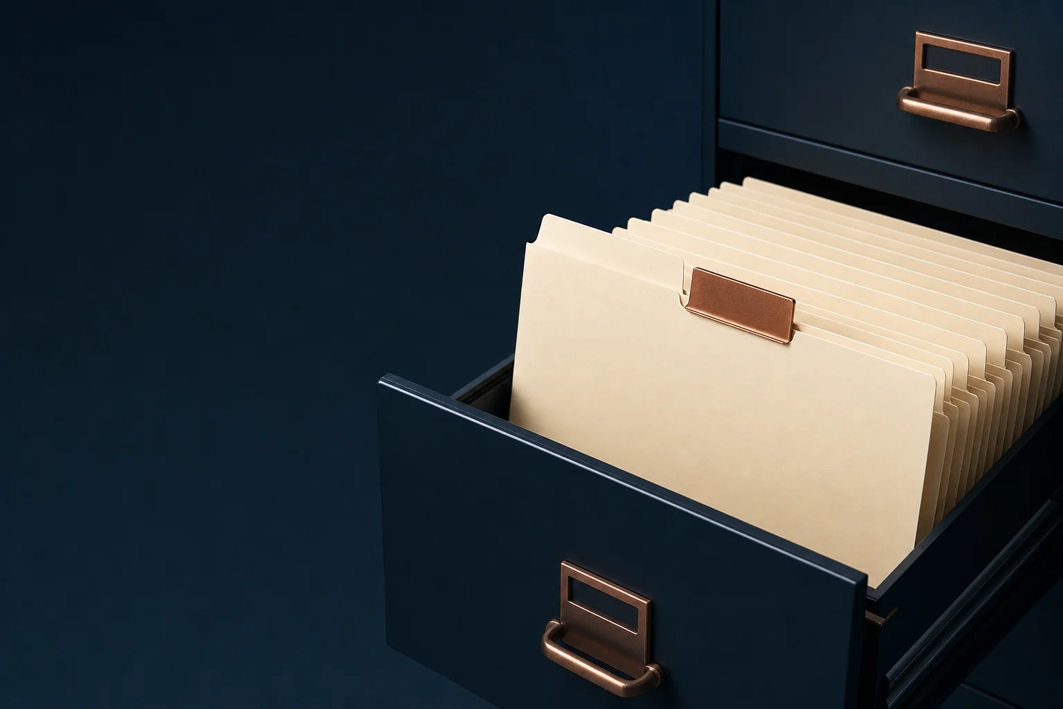 An open navy filing drawer holding blank ivory folders, with one folder pulled forward under a copper index tab